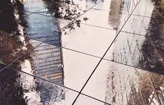 Reflection of skyscraper on wet pavers
