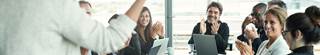 Group of business professionals clapping in a meeting.