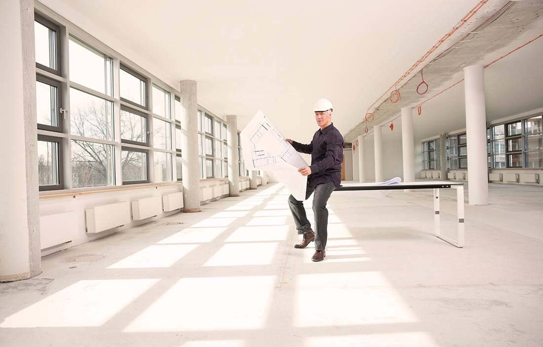 Construction worker/contractor sitting on a table looking at a blueprint.