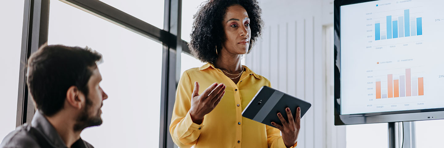 Business professional presenting to a group in a meeting.
