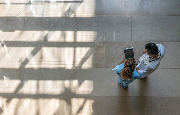 Two medical professionals review information on a tablet.