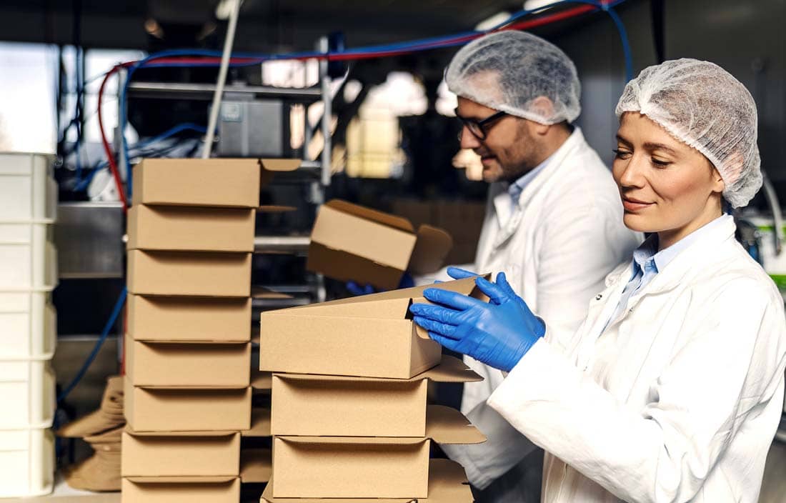 Factory workers packing boxes.