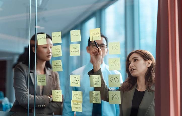 Business professionals brainstorming with sticky notes in an office.