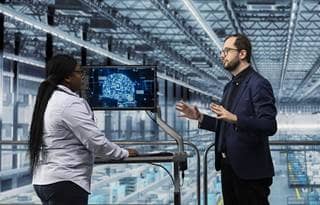 Manufacturing professionals discussing AI in a factory.