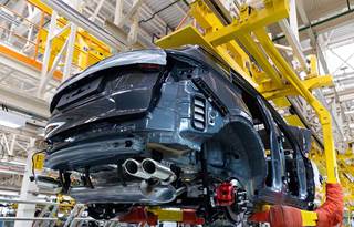 Automobile being assembled in a factory.