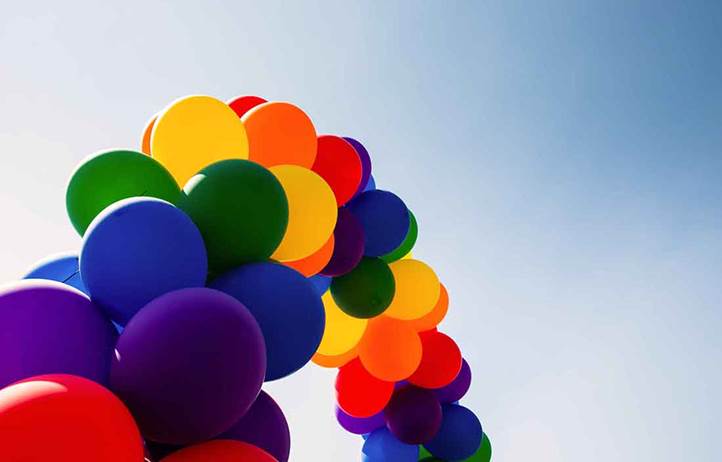 Multi-colored balloons on a rope in the shape of a rainbow