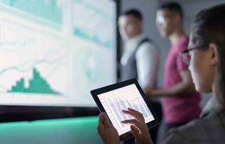 Business professional looking at a chart on their tablet computer.