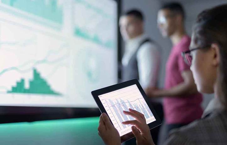 Business professional looking at a chart on their tablet computer.