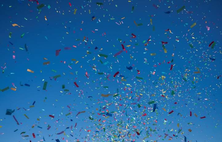 Colorful confetti on a dark blue background.