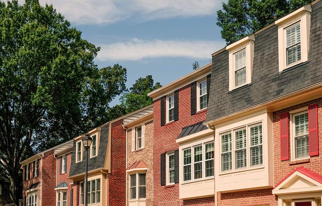 Row of townhouses in residential district with trees behind the buildings