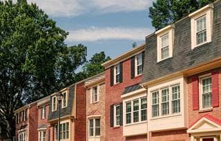 Row of townhouses in residential district with trees behind the buildings