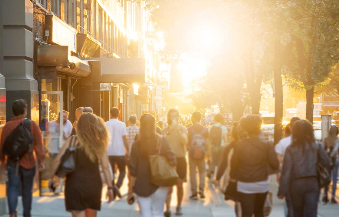 People walking with the sun shining.