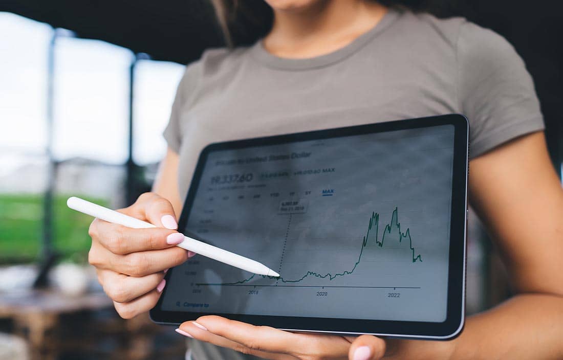 Woman holding a tablet pointing to a chart.